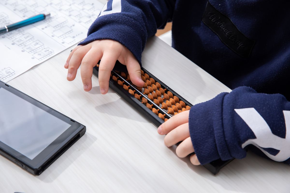 タブレットとそろばんを使って勉強する様子